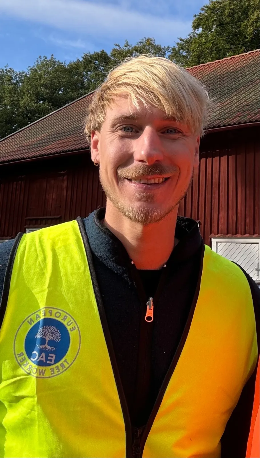 Arboristen i arbetskläder med EAC-märke